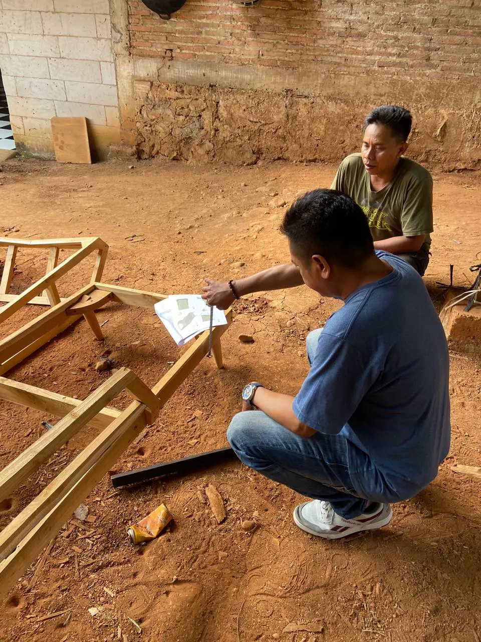 Two craftsmen checking frames against a drawing